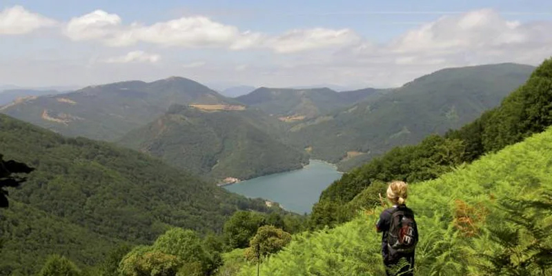 Niña contemplando en lo alto de una montaña un embalse en Navarra