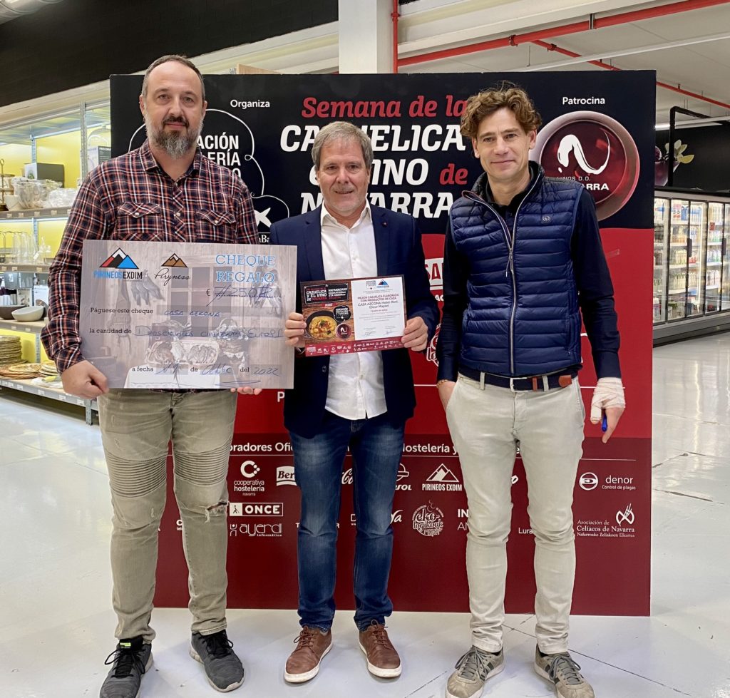 Recoge el premio el representante del Hotel Casa Azcona junto a dos miembros de la empresa Pirineos Exdim que le hacen entrega del diploma y un talón simbólico por valor de 250 euros para la compra de productos de caza.