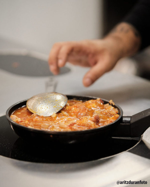 En un sartén se calientan los ingredientes de su cazuelica a base de morros. Restaurante Bodega Castillo de Monjardin. la foto es de @aritzduranfoto